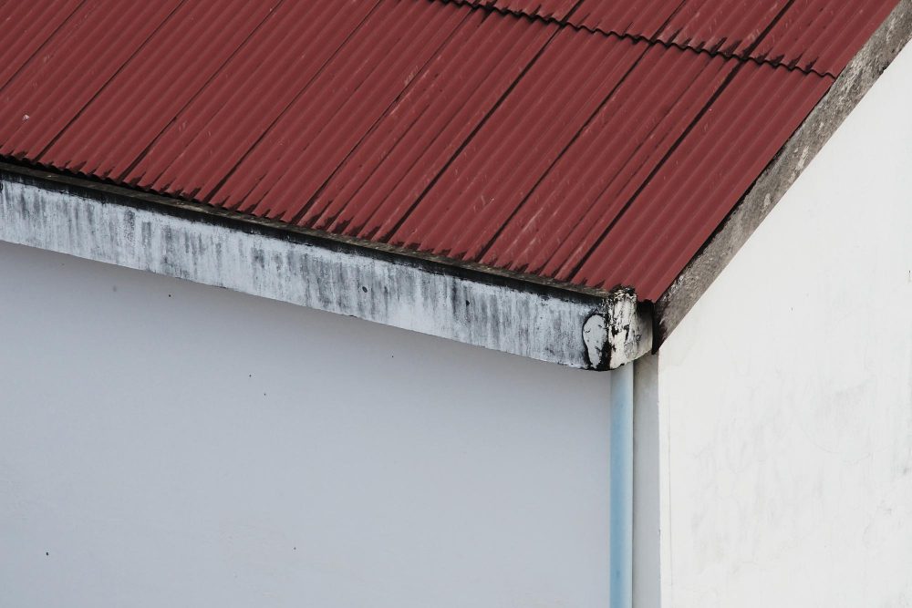 Toit en tôle rouge d'une maison blanche