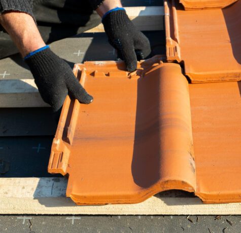 Pose de tuiles sur un toit en construction.