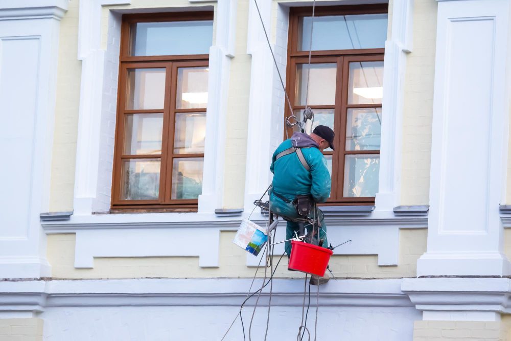 Laveur de vitres suspendu à un bâtiment.
